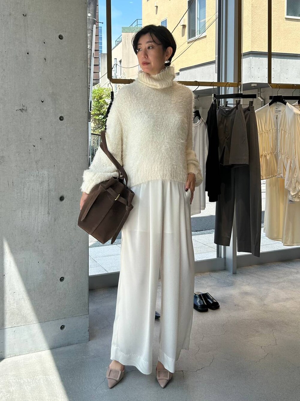 ホワイト系のニット/セーター、ホワイト系のその他パンツ、ブラウン系のピーコートを着用したレディースの秋コーディネートの2枚目の写真