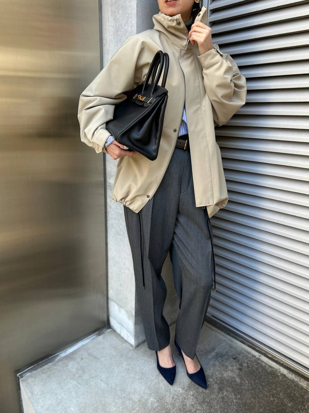 グレー系のニット/セーター、ブルー系のシャツ/ブラウス、グレー系のスラックスを着用したレディースの冬コーディネートの5枚目の写真