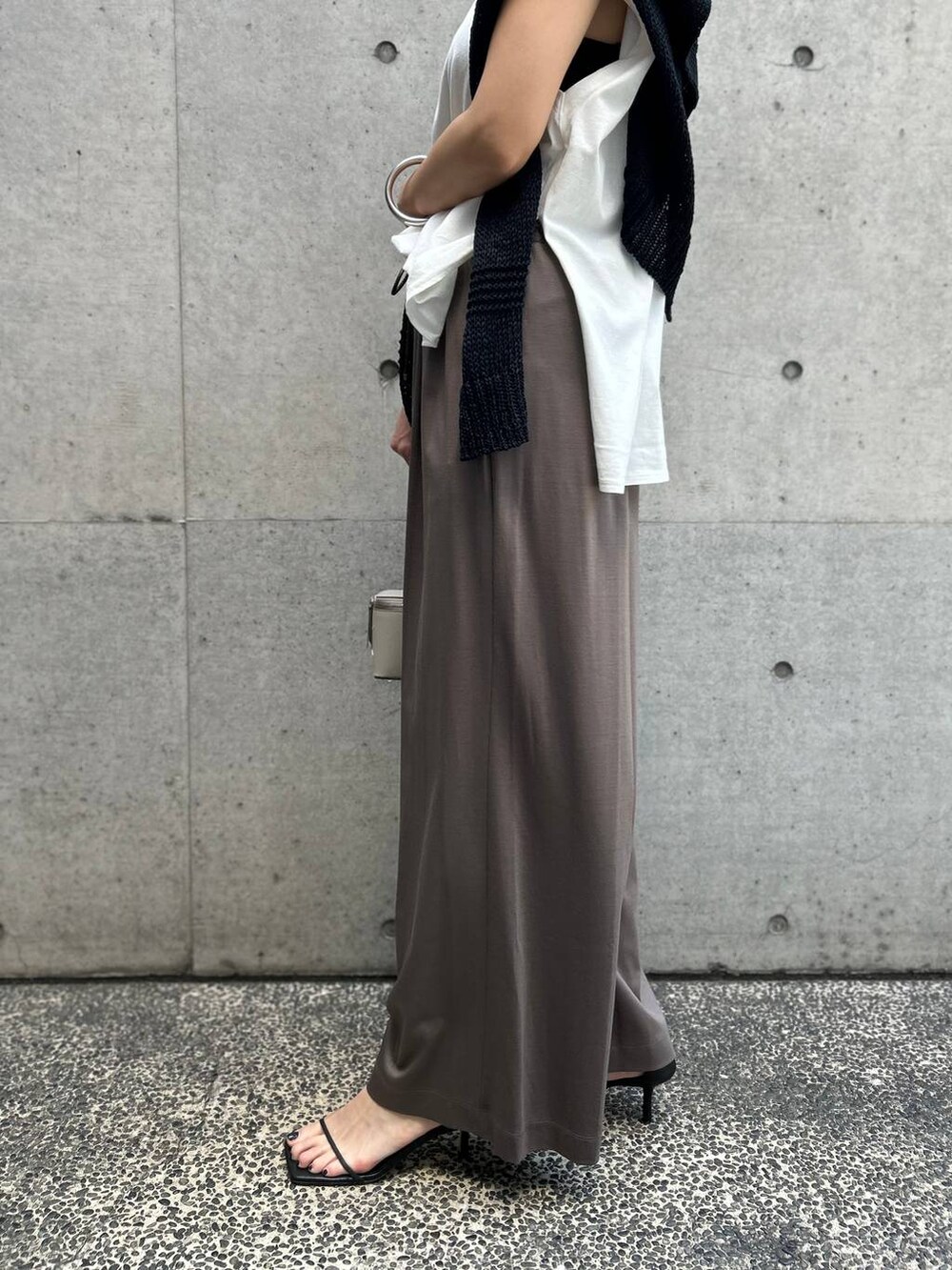 ホワイト系のTシャツ/カットソー、ブラック系のアンサンブル、ブラック系のサンダルを着用したレディースの春コーディネートの8枚目の写真