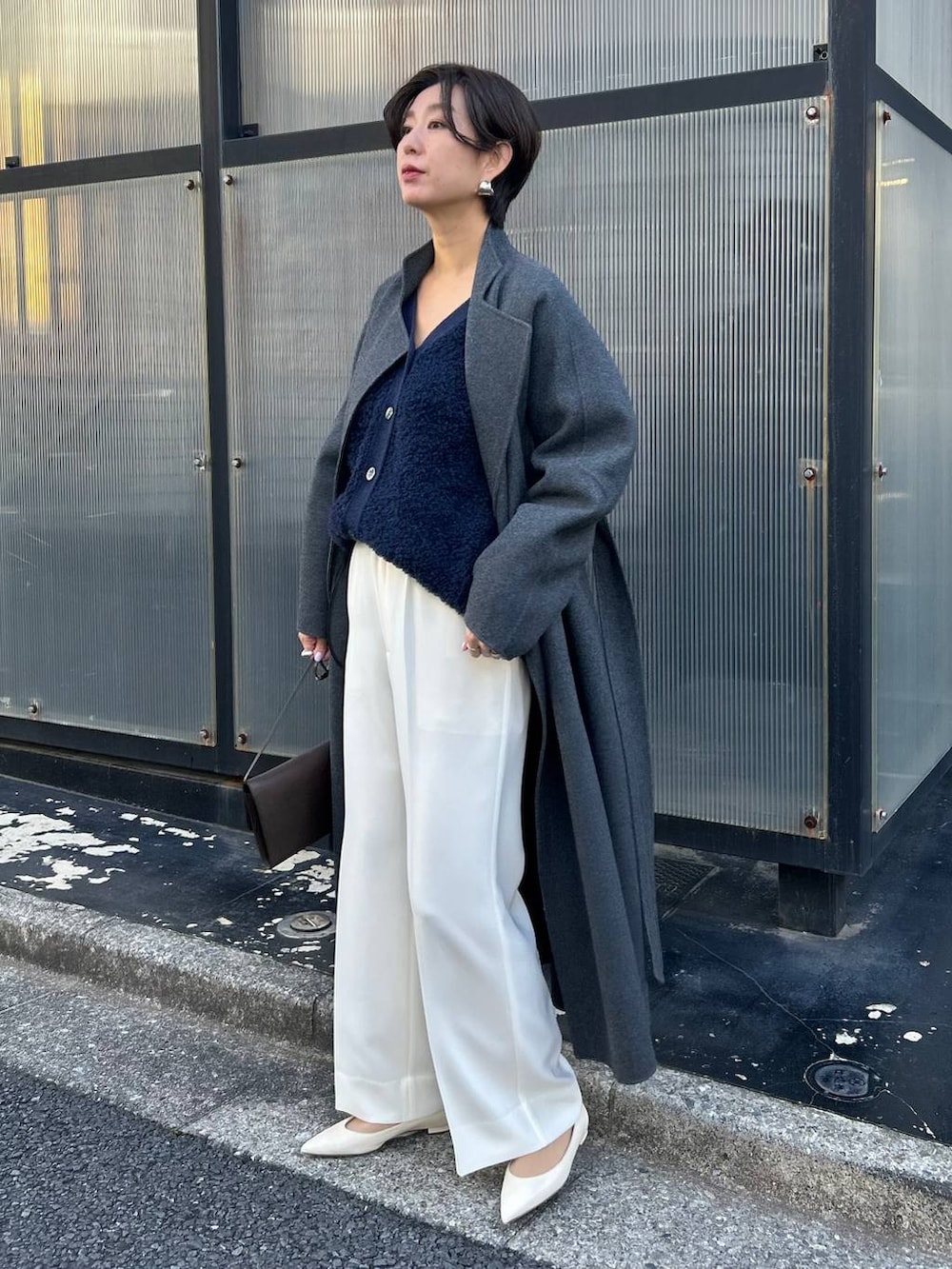 ブルー系のカーディガン/ボレロ、グレー系のノーカラーコート、ホワイト系のスラックスを着用したレディースの冬コーディネートの3枚目の写真