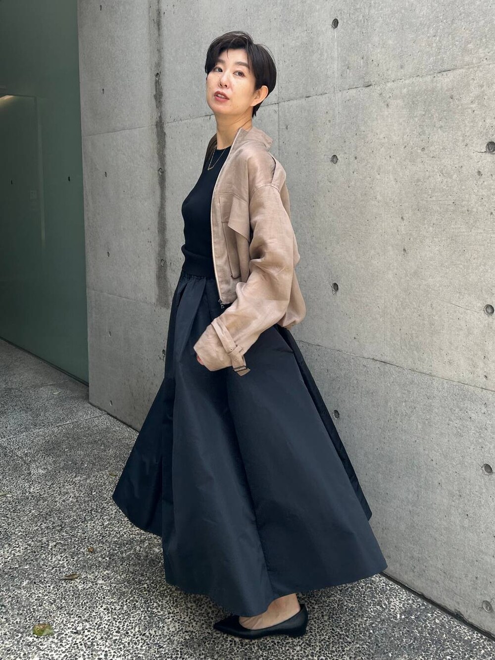 グレー系のブルゾン、ブラック系のスカート、ブラウン系のニット/セーターを着用したレディースの春コーディネートの4枚目の写真