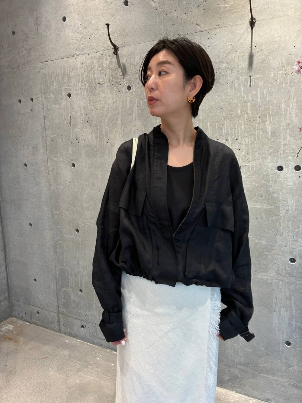 ブラック系のシャツ/ブラウス、ブラック系のブルゾン、ホワイト系のスカートを着用したレディースの春コーディネートの6枚目の写真