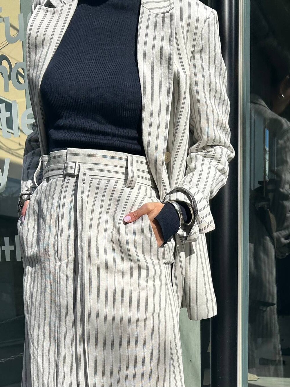 ブルー系のニット/セーター、ホワイト系のテーラードジャケット、ホワイト系のスカートを着用したレディースの冬コーディネートの9枚目の写真