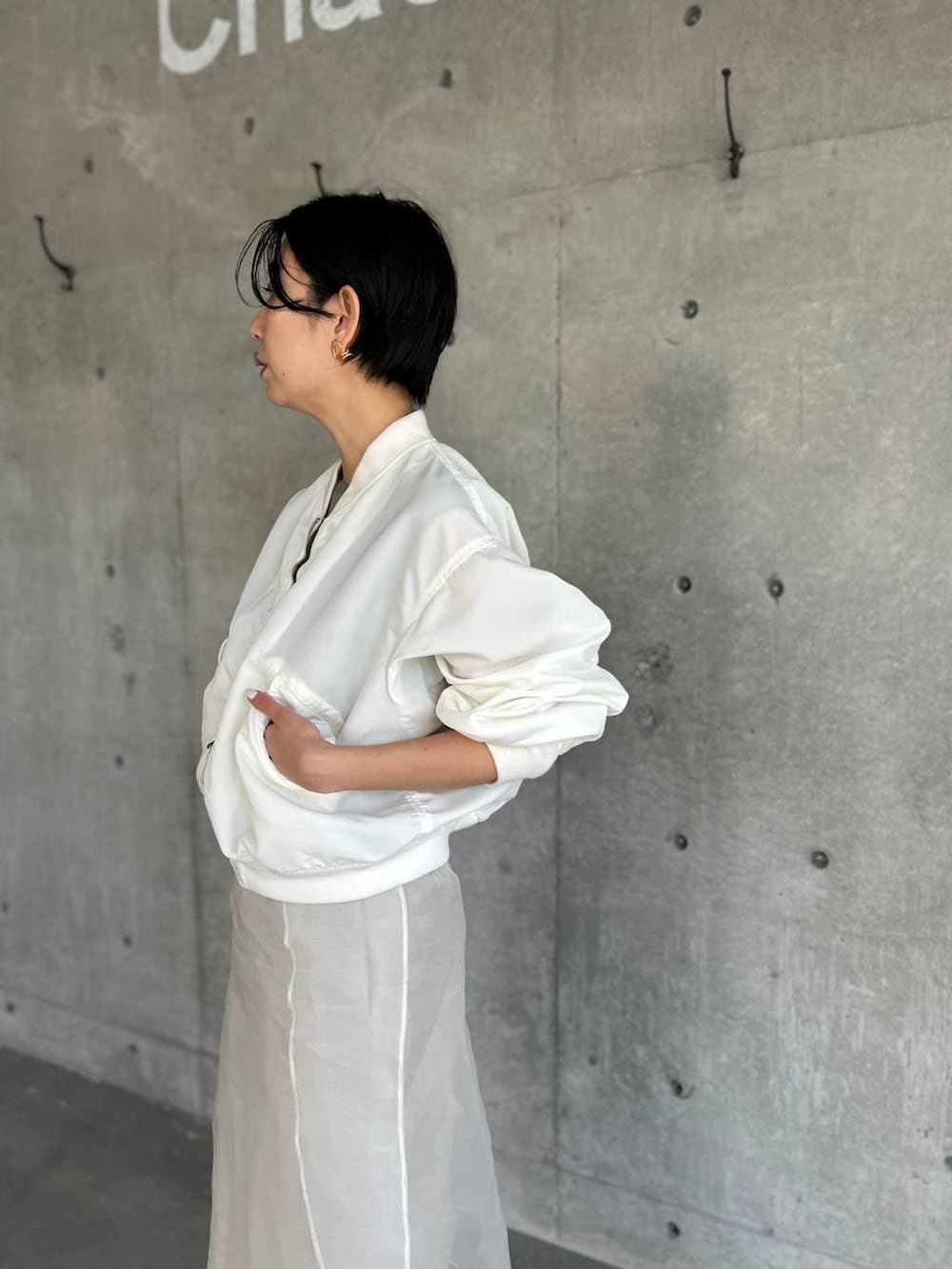 ベージュ系のスカート、ホワイト系のMA-1を着用したレディースの春コーディネートの5枚目の写真