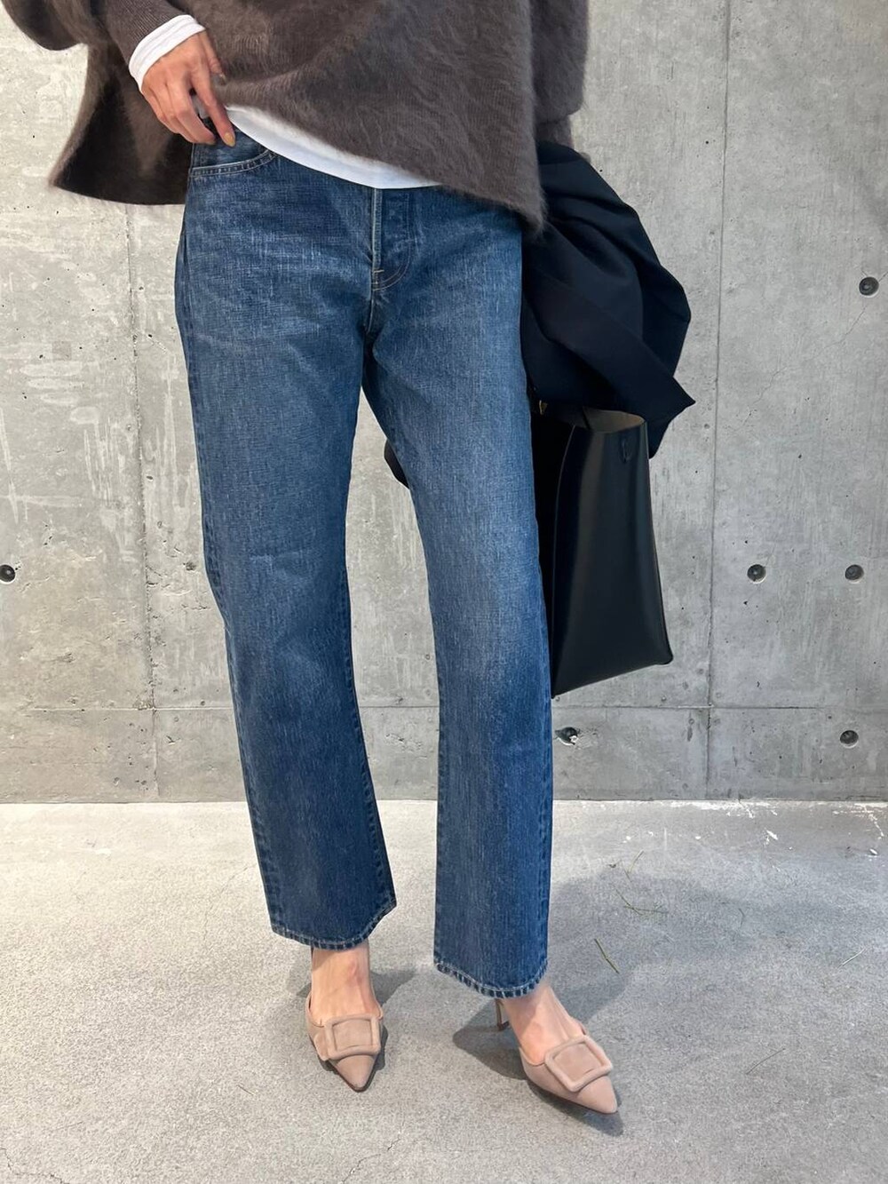 ブルー系のデニムパンツ、ブラウン系のニット/セーター、ホワイト系のTシャツ/カットソーを着用したレディースの秋コーディネートの3枚目の写真