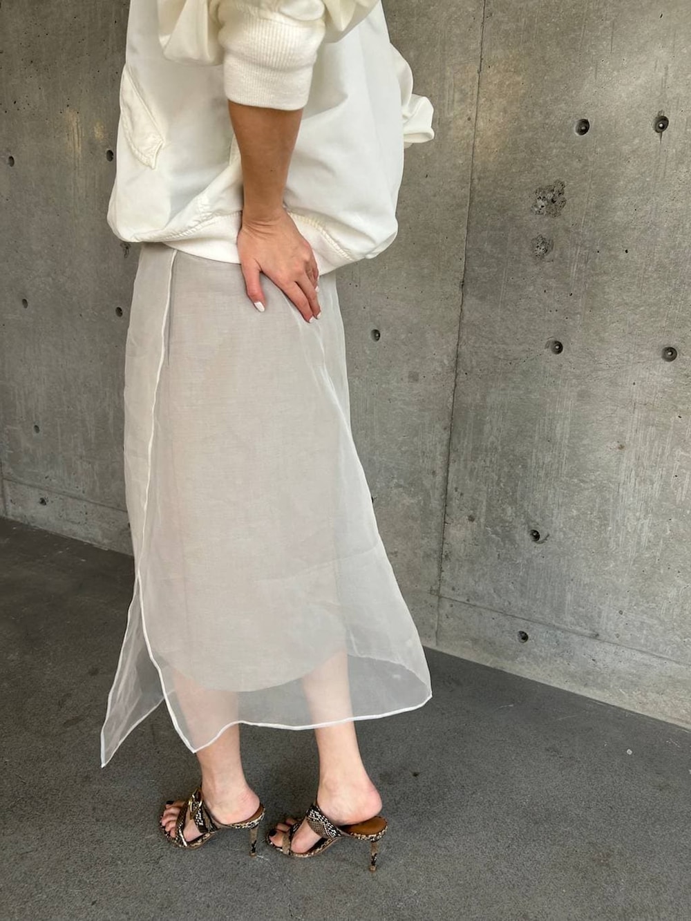 ベージュ系のスカート、ホワイト系のMA-1を着用したレディースの春コーディネートの9枚目の写真