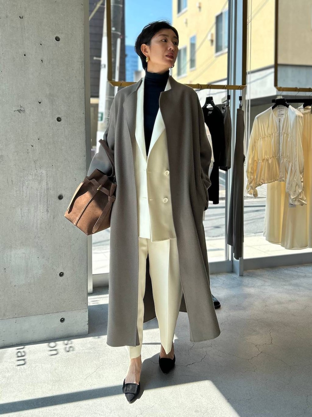 ブルー系のニット/セーター、ブラウン系のノーカラーコート、ホワイト系のテーラードジャケットを着用したレディースの秋コーディネートの8枚目の写真