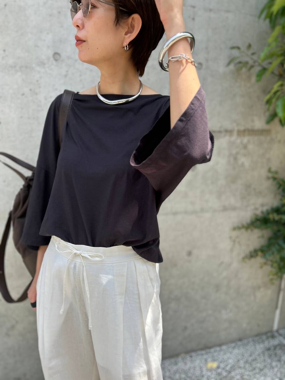 ブラック系のチューブトップ、ホワイト系のスラックス、グレー系のTシャツ/カットソーを着用したレディースの春コーディネートの7枚目の写真