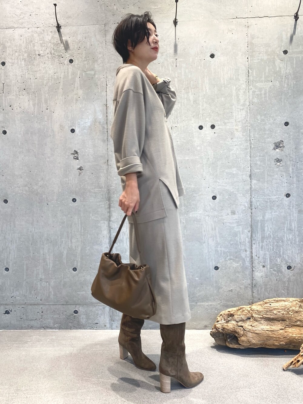 ベージュ系のスカート、ベージュ系のブーツ、ブラウン系のバッグを着用したレディースの秋コーディネートの3枚目の写真