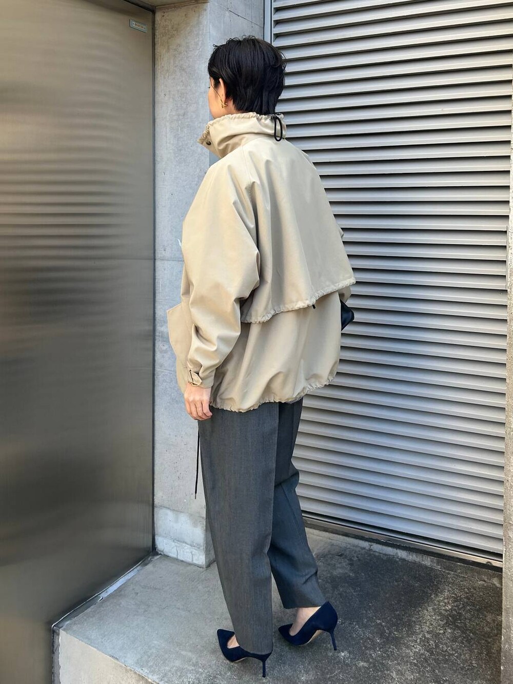 グレー系のニット/セーター、ブルー系のシャツ/ブラウス、グレー系のスラックスを着用したレディースの冬コーディネートの3枚目の写真