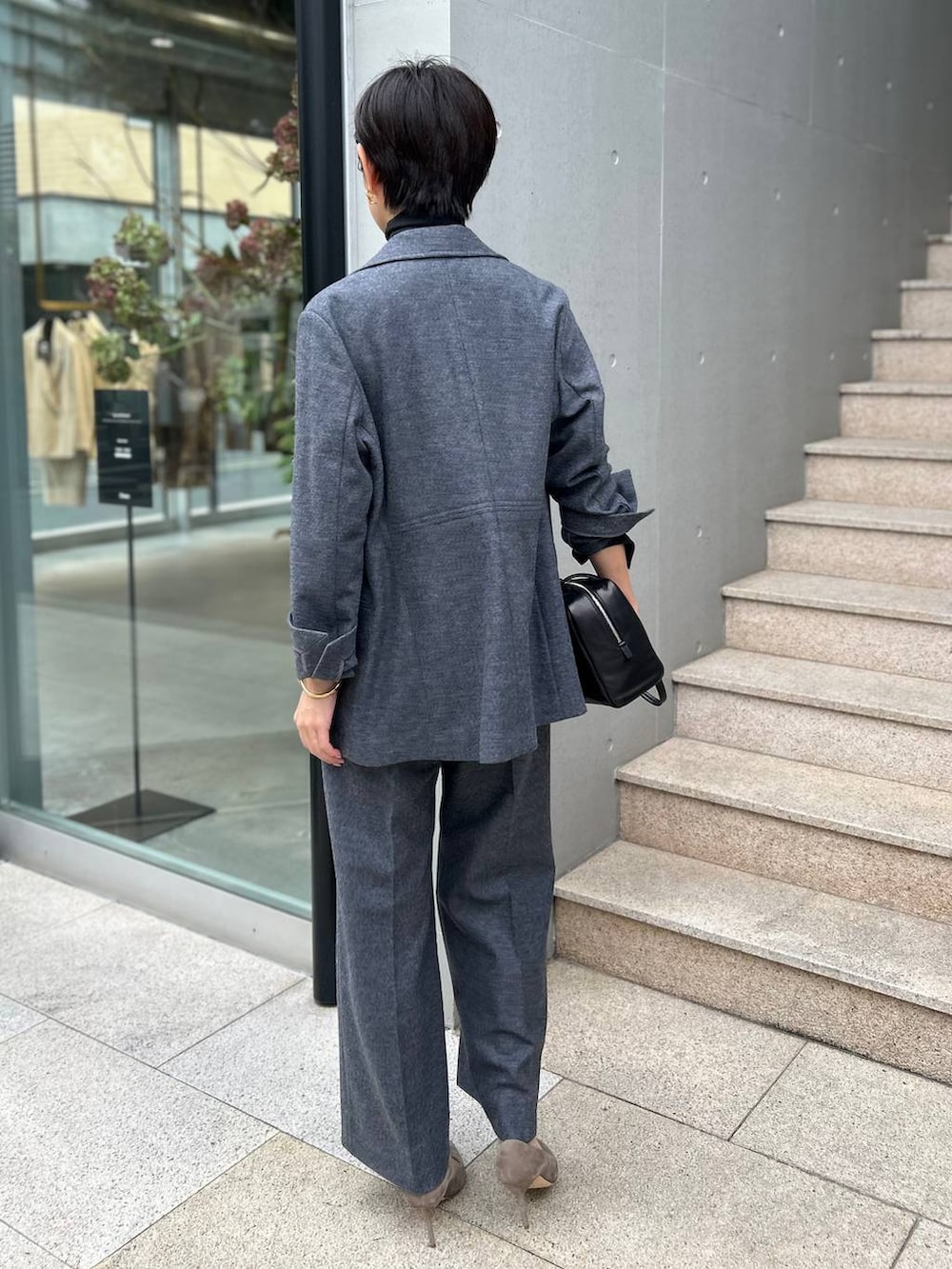 ブラック系のニット/セーター、グレー系のブルゾン、ホワイト系のスラックスを着用したレディースの秋コーディネートの7枚目の写真