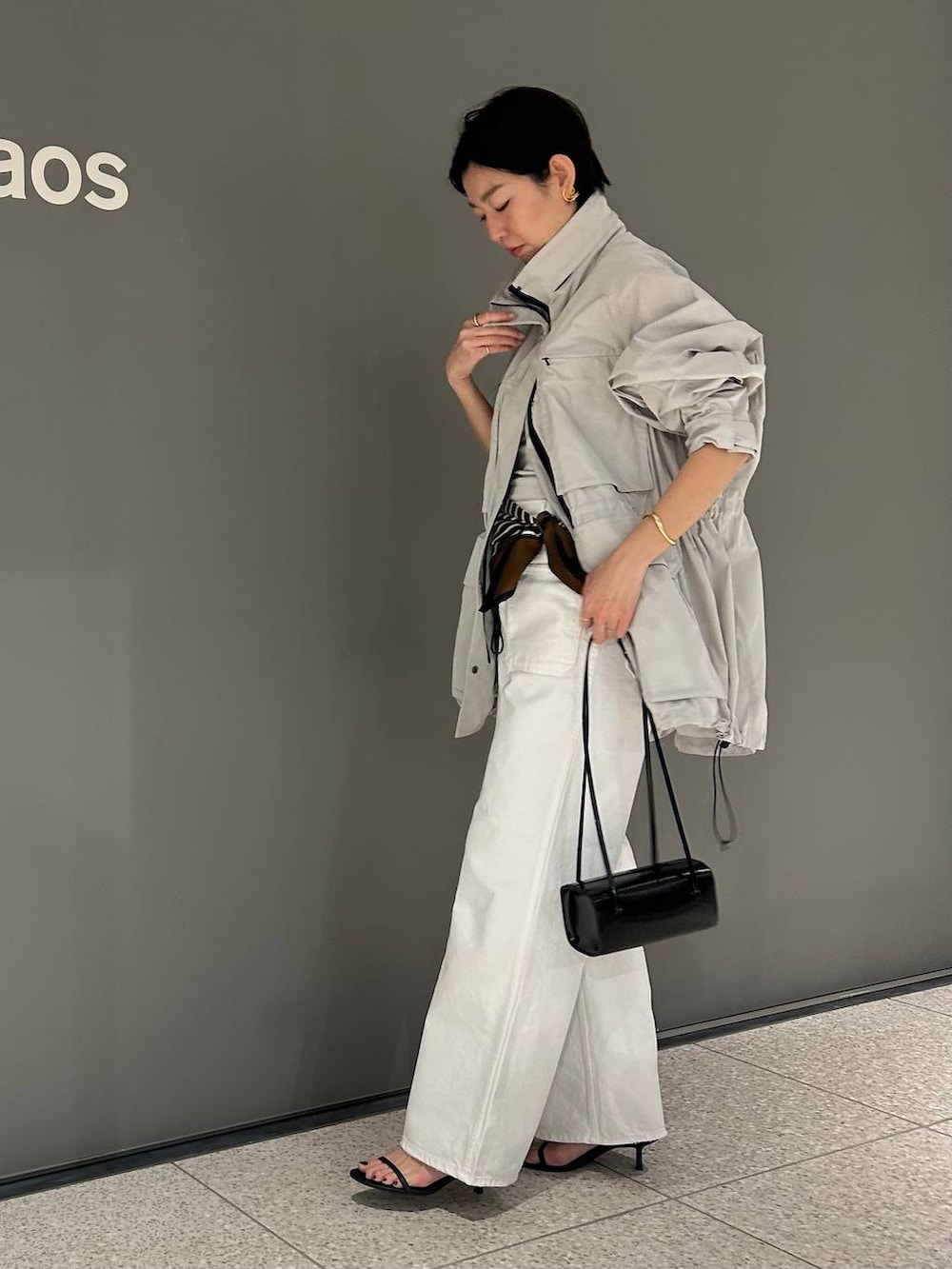 ホワイト系のデニムパンツ、ホワイト系のタンクトップ、グレー系のブルゾンを着用したレディースの春コーディネートの4枚目の写真