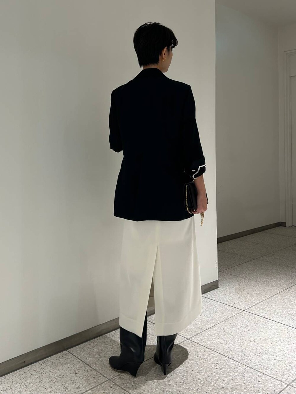 ブラック系のテーラードジャケットを着用したレディースの秋コーディネートの7枚目の写真