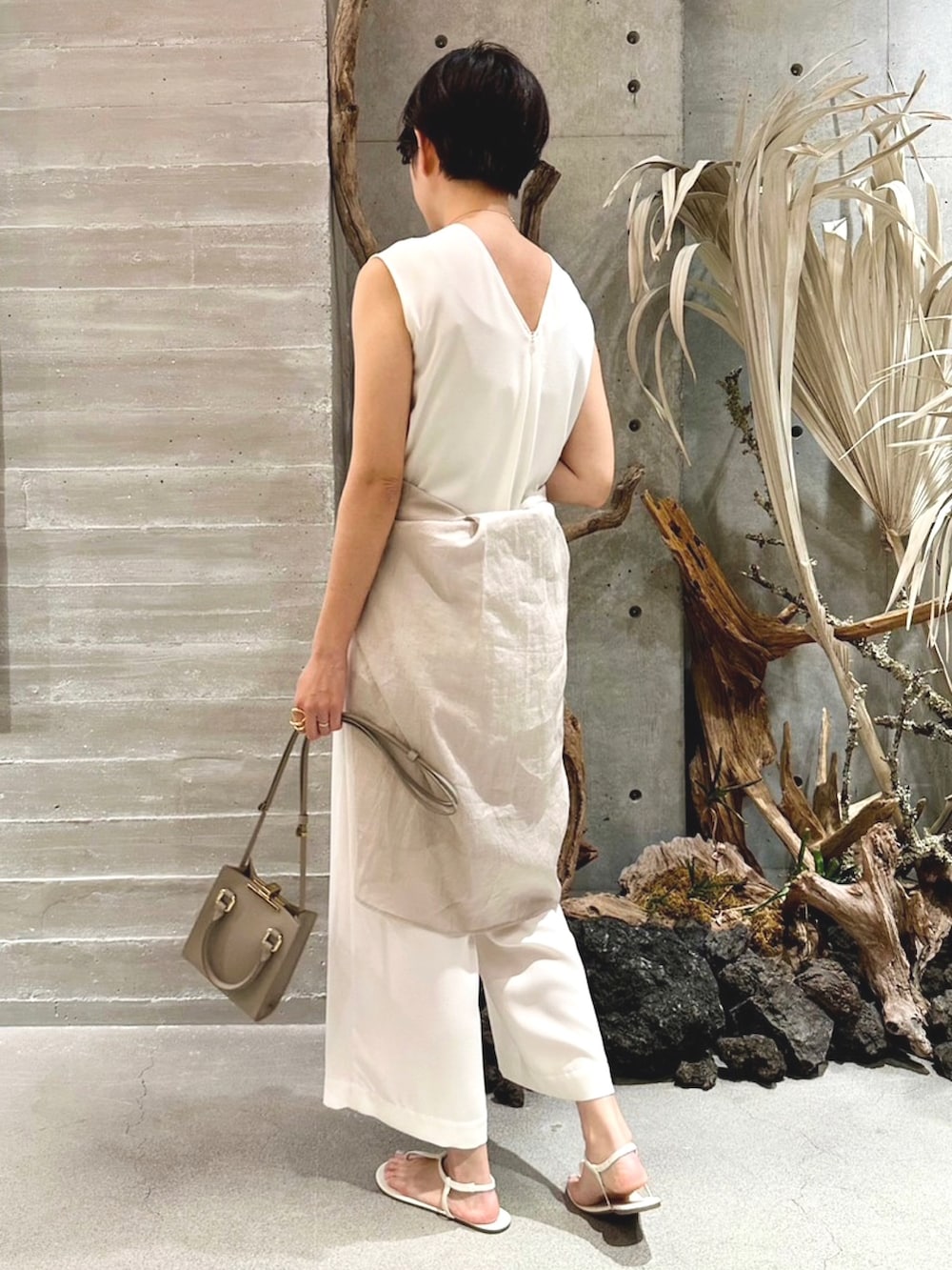 ベージュ系のシャツ/ブラウス、ベージュ系のサロペット/オーバーオール、ベージュ系のバッグを着用したレディースの春コーディネートの4枚目の写真