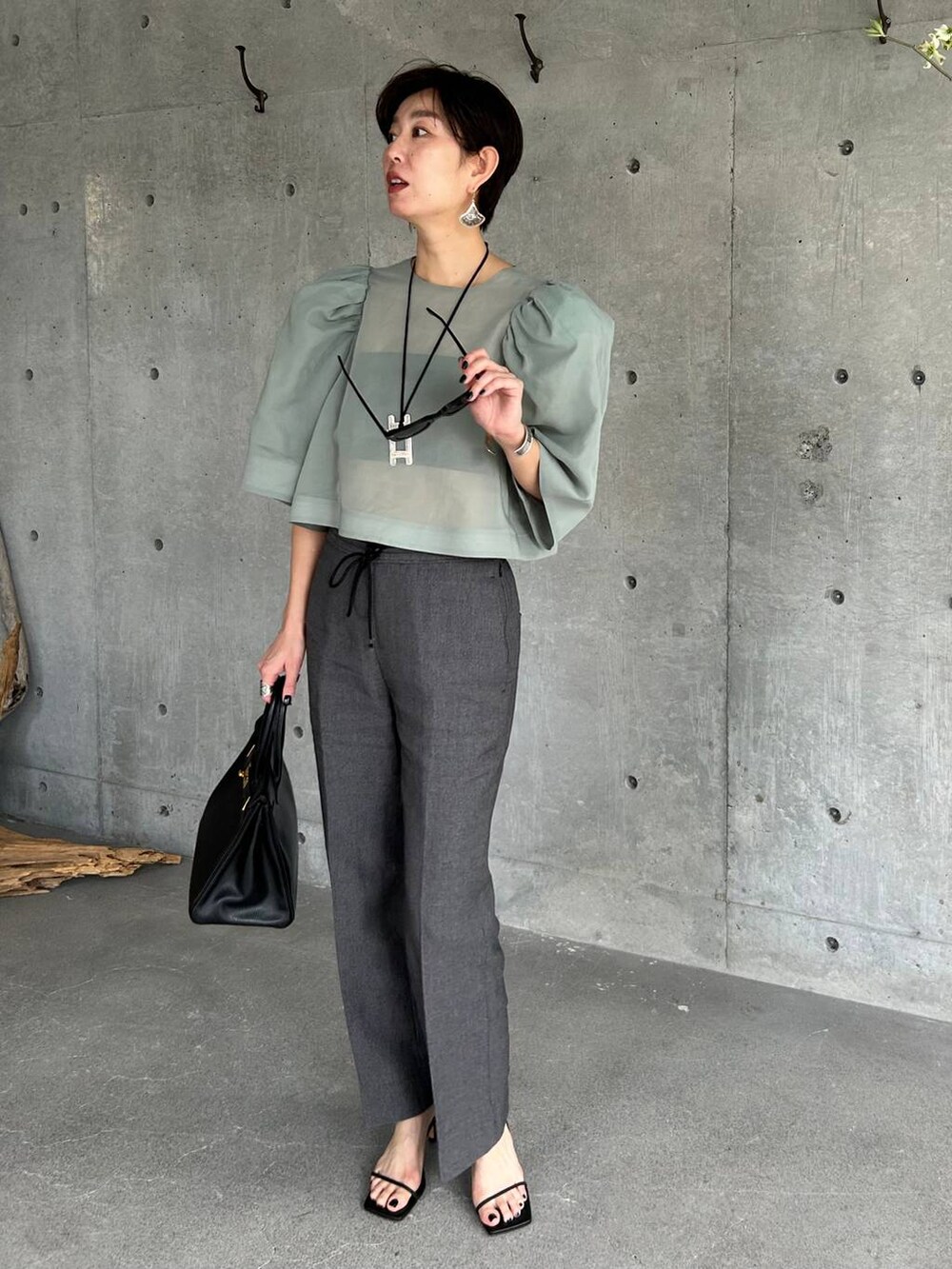 ブラック系のチューブトップ、ブラック系のその他パンツ、グリーン系のシャツ/ブラウスを着用したレディースの春コーディネートの2枚目の写真