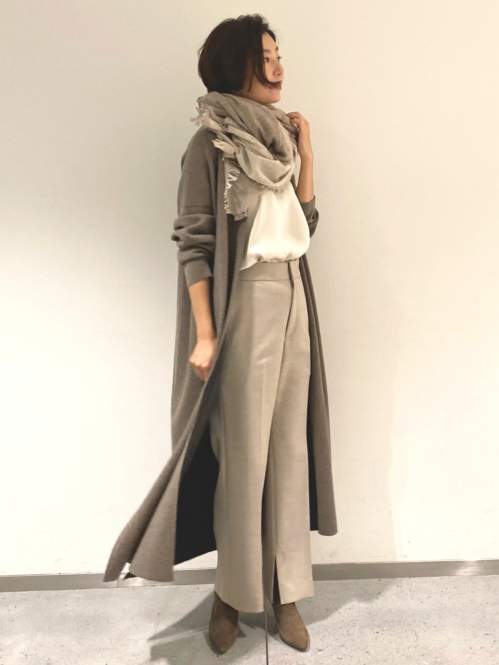 ホワイト系のシャツ/ブラウス、ブラウン系のカーディガン/ボレロ、ベージュ系のその他パンツを着用したレディースの秋コーディネートの2枚目の写真
