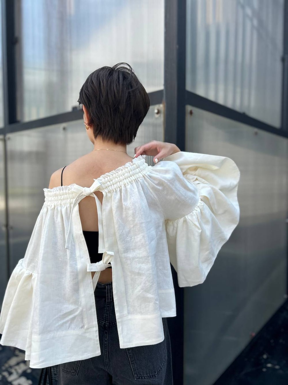 ブラック系のチューブトップ、ホワイト系のシャツ/ブラウス、ブラック系のデニムパンツを着用したレディースの春コーディネートの7枚目の写真