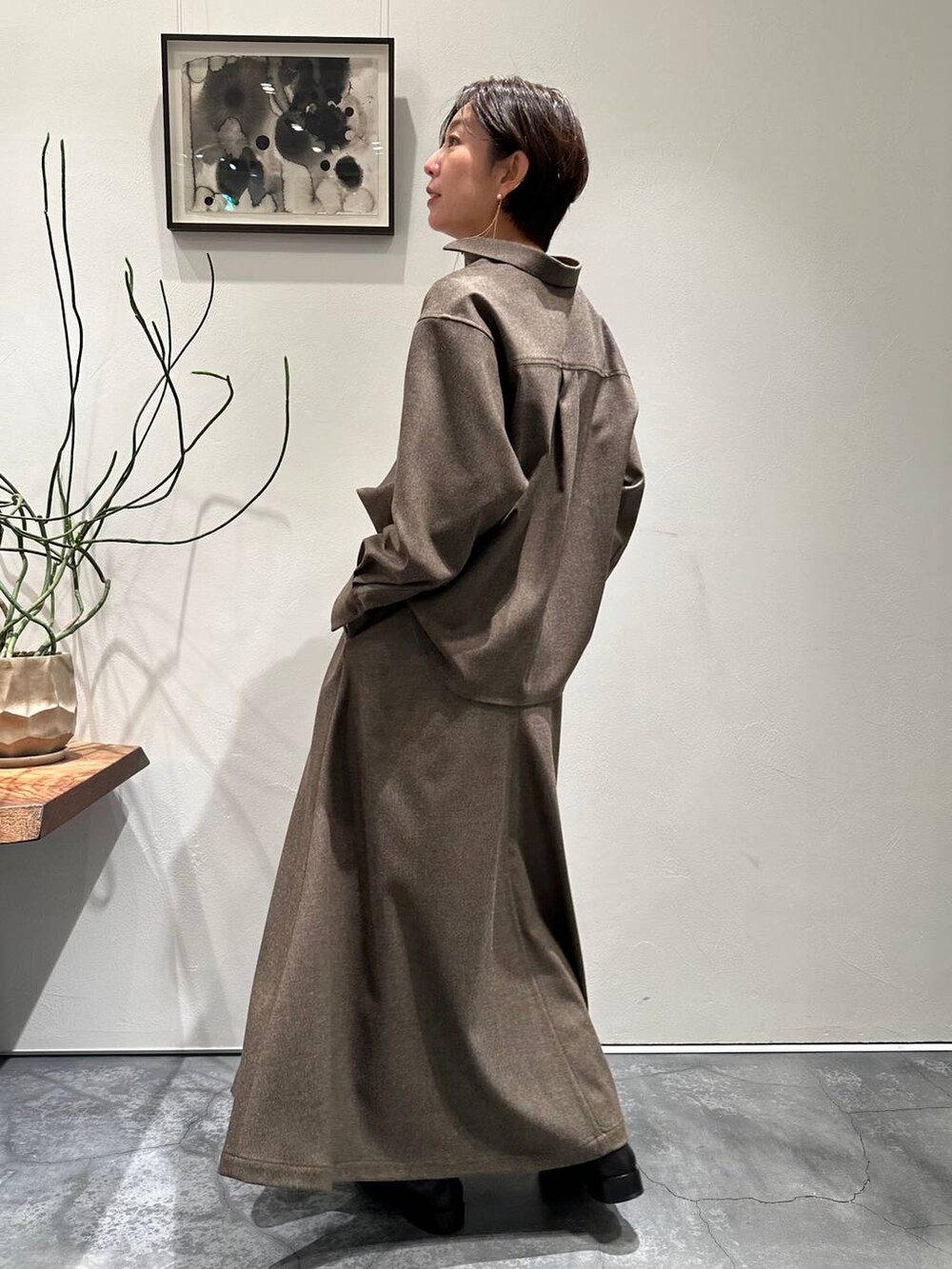 ブルー系のカーディガン/ボレロ、ブラック系のブーツ、ブラウン系のスカートを着用したレディースの冬コーディネートの5枚目の写真