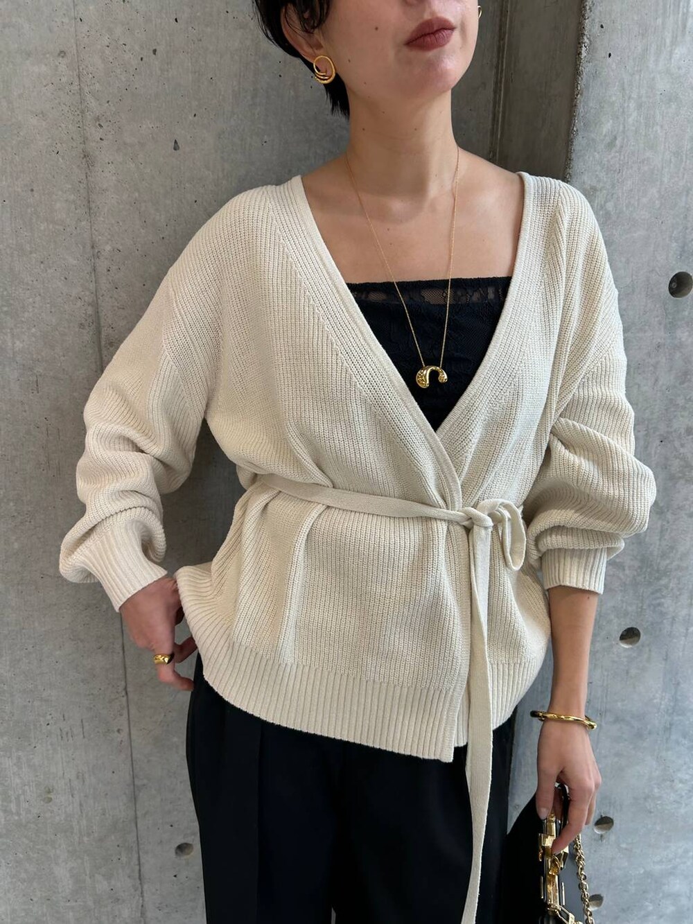 ブラック系のその他トップス、ホワイト系のカーディガン/ボレロ、ブラック系のスラックスを着用したレディースの冬コーディネートの5枚目の写真