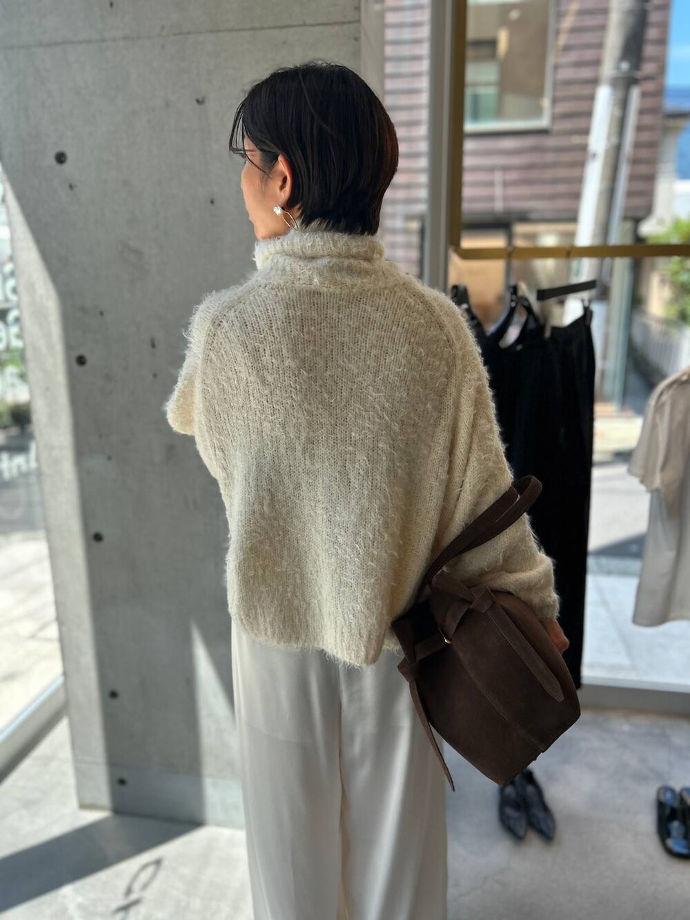 ホワイト系のニット/セーター、ホワイト系のその他パンツ、ブラウン系のピーコートを着用したレディースの秋コーディネートの7枚目の写真