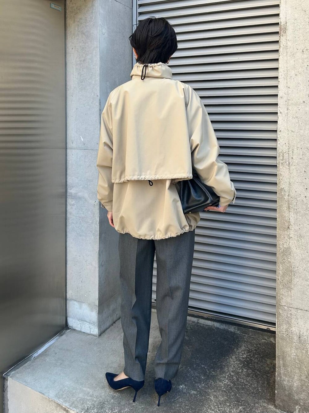 グレー系のニット/セーター、ブルー系のシャツ/ブラウス、グレー系のスラックスを着用したレディースの冬コーディネートの4枚目の写真