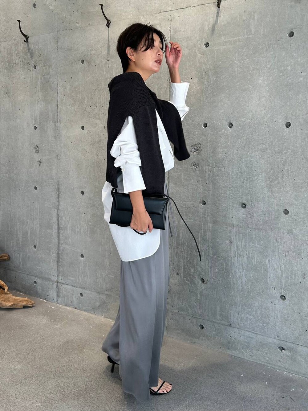 グレー系のその他パンツ、ブラック系のサンダル、グレー系のニット/セーターを着用したレディースの秋コーディネートの2枚目の写真