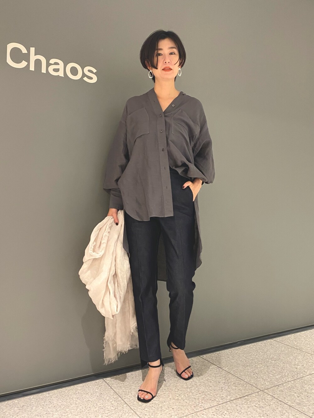 グレー系のシャツ/ブラウス、ブルー系のデニムパンツ、ブラック系のサンダルを着用したレディースの春コーディネートの2枚目の写真