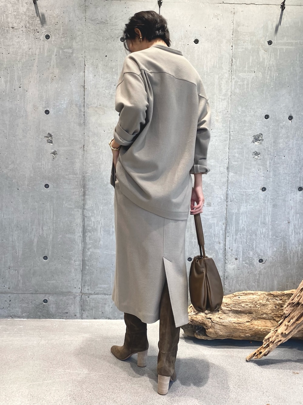 ベージュ系のスカート、ベージュ系のブーツ、ブラウン系のバッグを着用したレディースの秋コーディネートの2枚目の写真