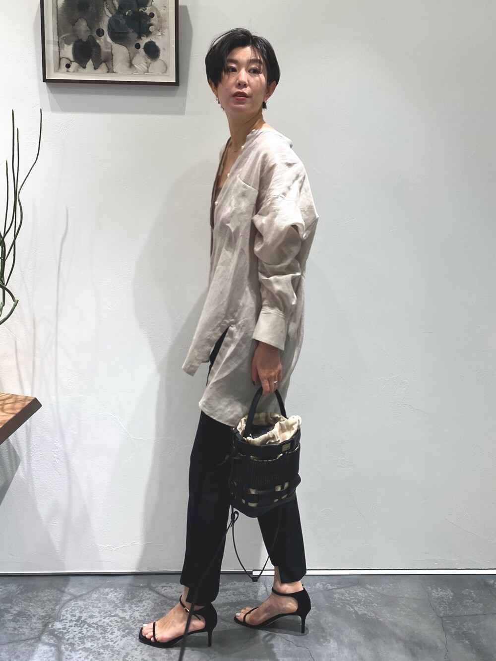 ベージュ系のシャツ/ブラウス、ブラウン系のチューブトップ、ブラック系のバッグを着用したレディースの春コーディネートの3枚目の写真