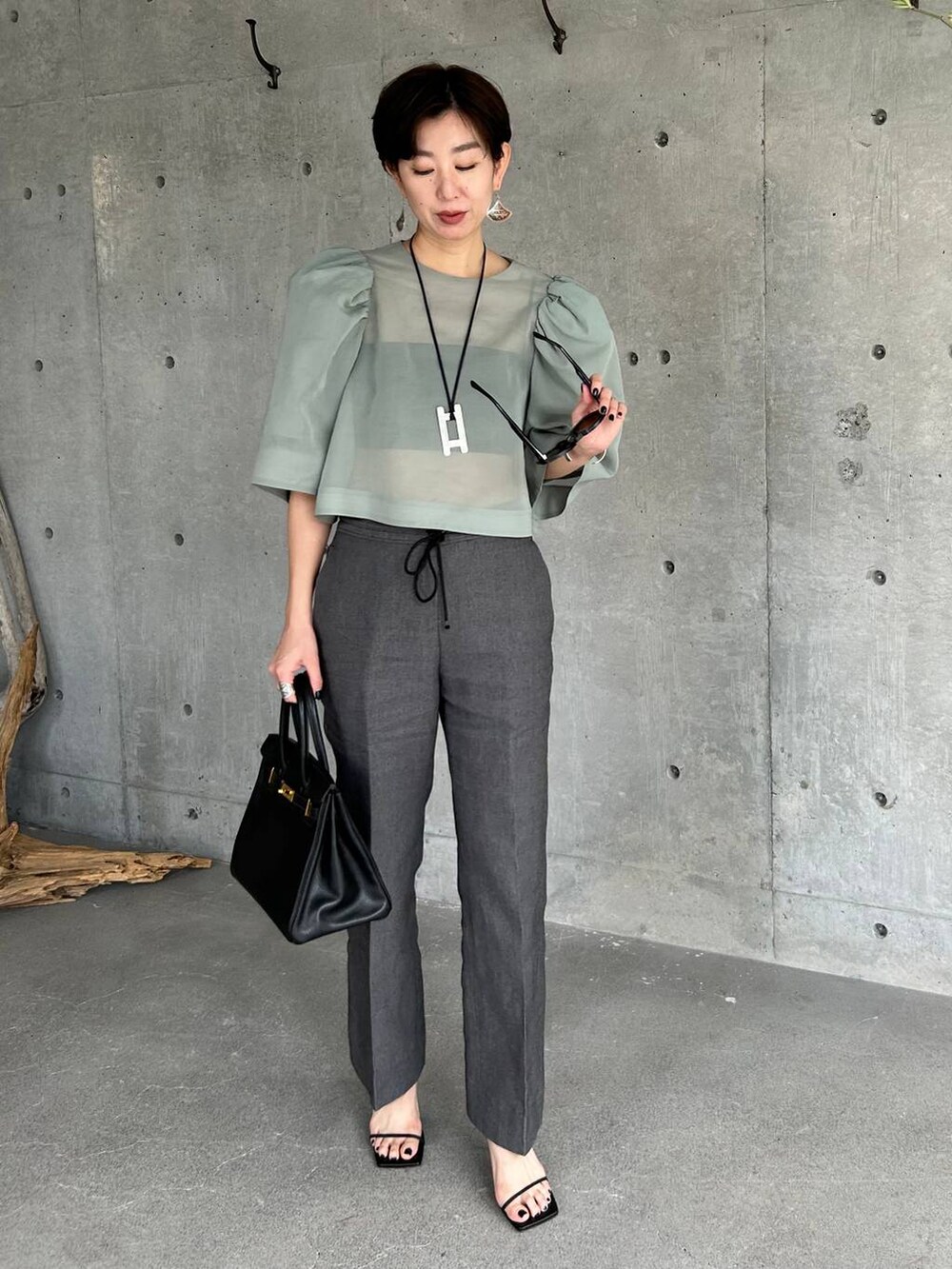 ブラック系のチューブトップ、ブラック系のその他パンツ、グリーン系のシャツ/ブラウスを着用したレディースの春コーディネートの3枚目の写真