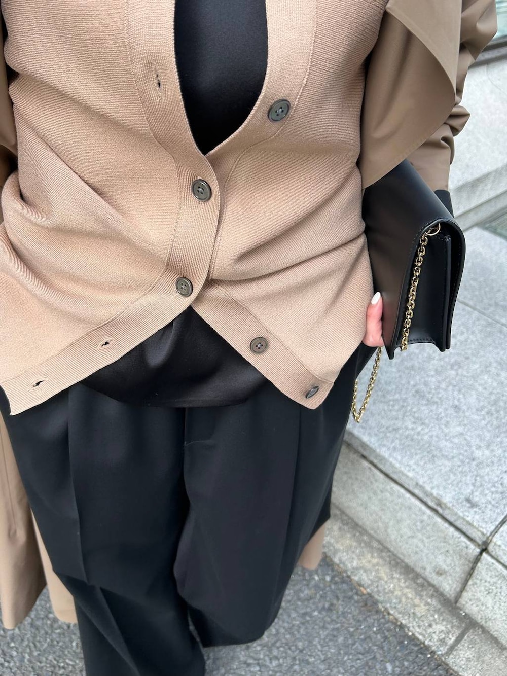 ブラック系のキャミソール、ブラック系のスラックス、ブラウン系のカーディガン/ボレロを着用したレディースの冬コーディネートの6枚目の写真