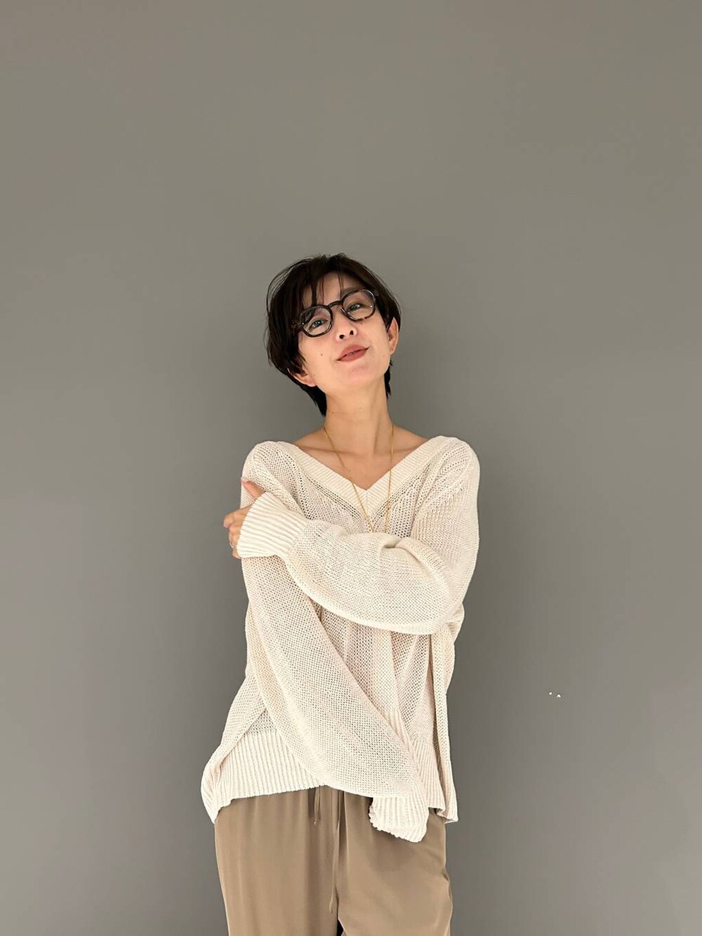 ベージュ系のその他パンツ、ホワイト系のニット/セーターを着用したレディースの夏コーディネートの6枚目の写真