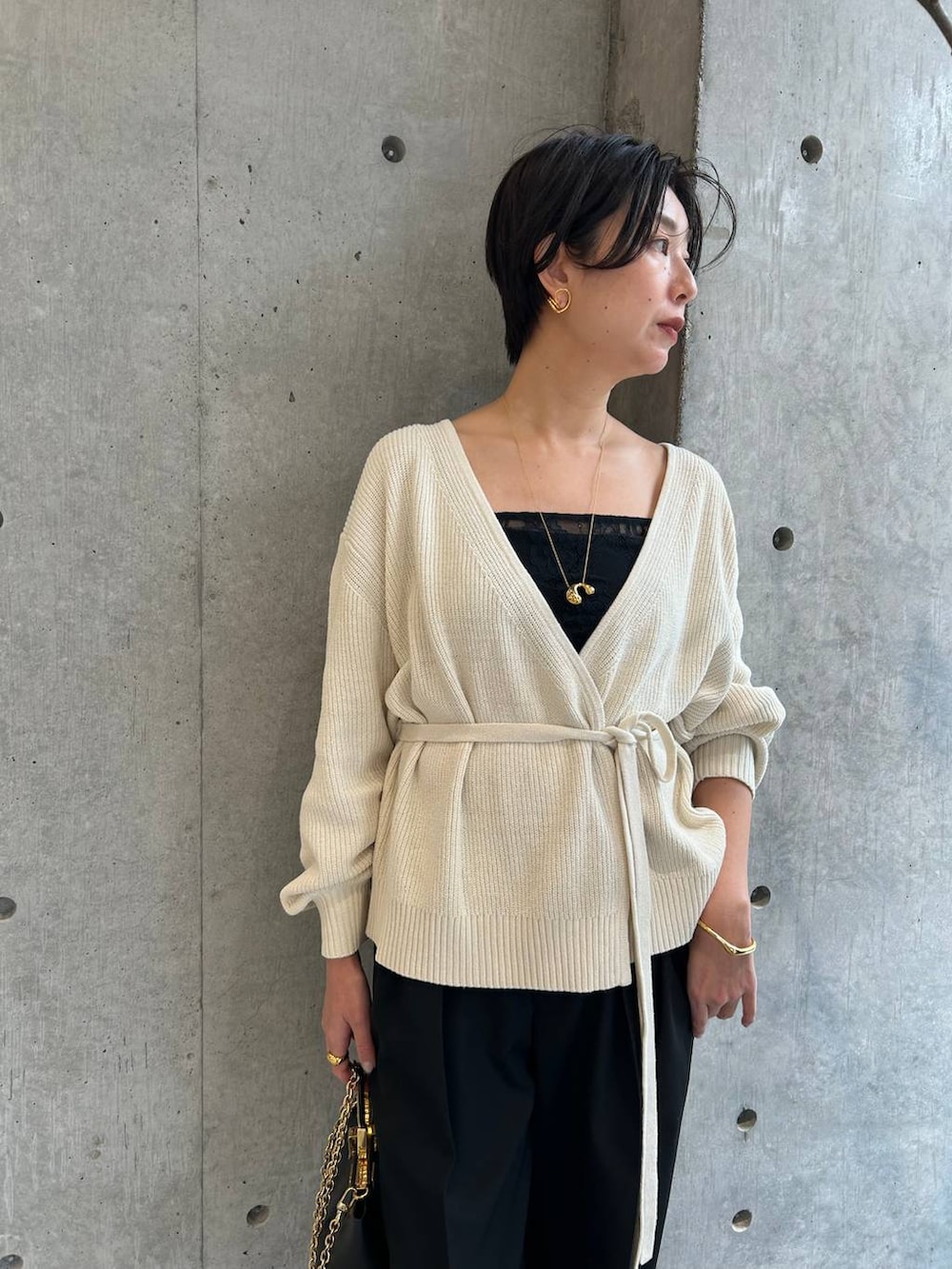 ブラック系のその他トップス、ホワイト系のカーディガン/ボレロ、ブラック系のスラックスを着用したレディースの冬コーディネートの4枚目の写真