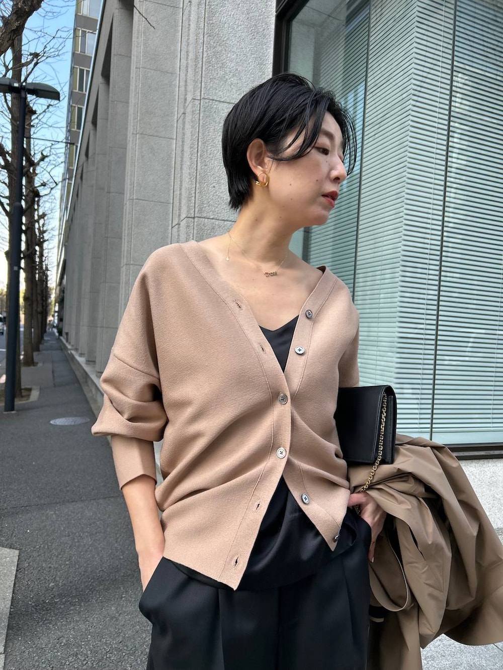 ブラック系のキャミソール、ブラック系のスラックス、ブラウン系のカーディガン/ボレロを着用したレディースの冬コーディネートの7枚目の写真