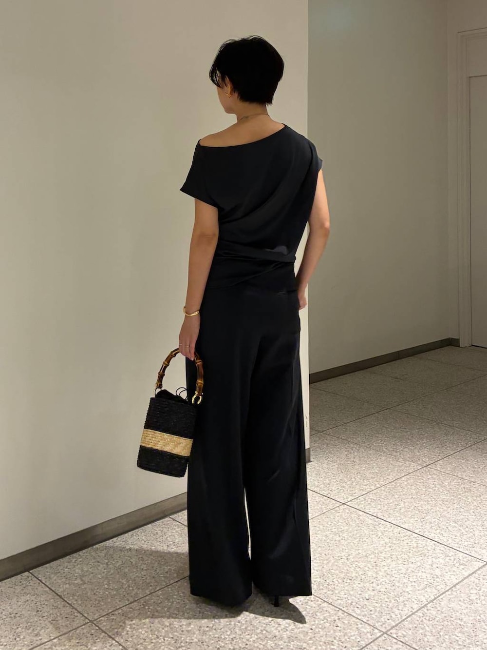 グレー系のその他パンツ、グレー系のTシャツ/カットソー、ベージュ系のハンドバッグを着用したレディースの夏コーディネートの3枚目の写真