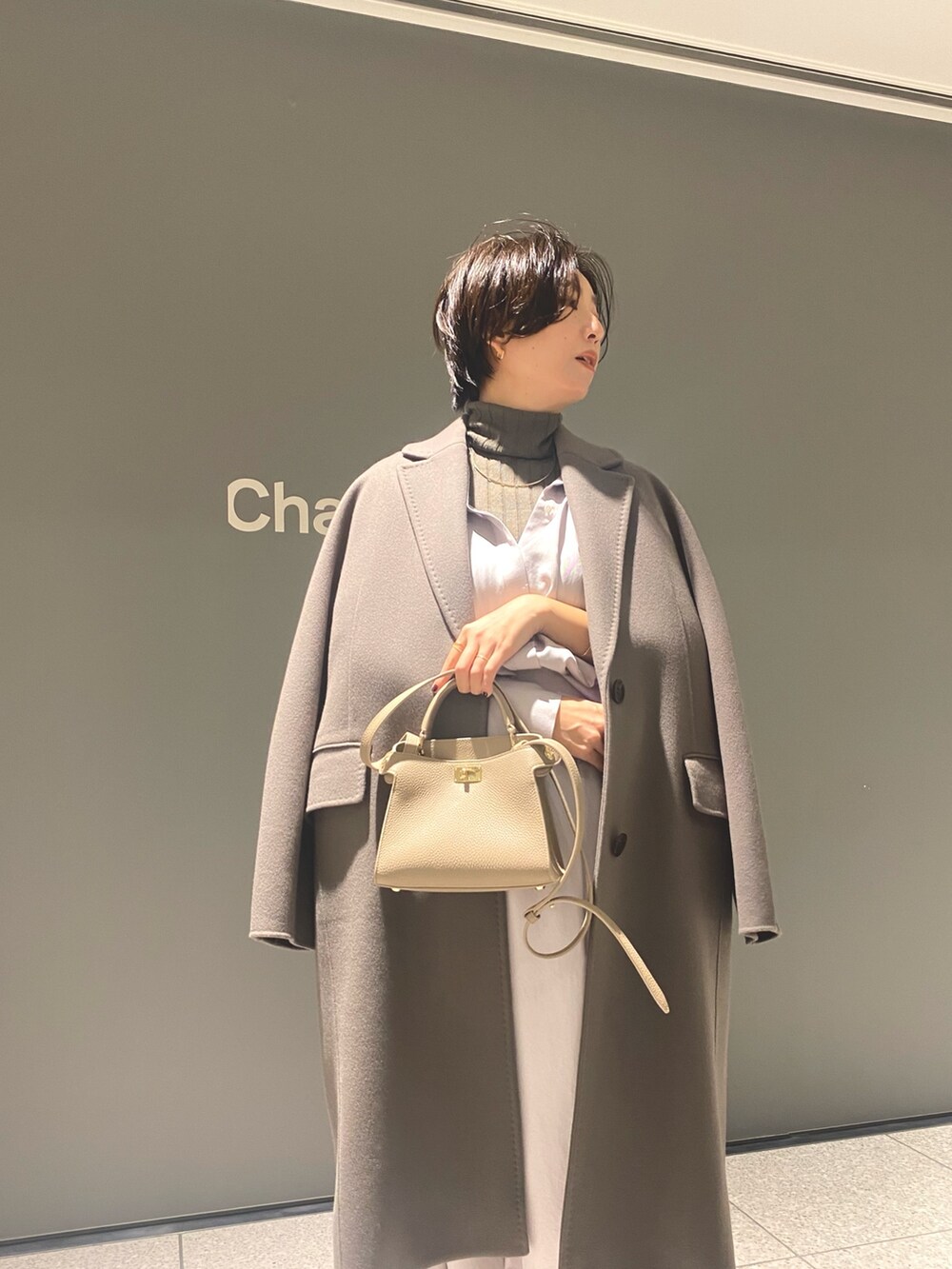 グレー系のスカート、ベージュ系のブーツ、ブラウン系のその他アウターを着用したレディースの冬コーディネートの6枚目の写真