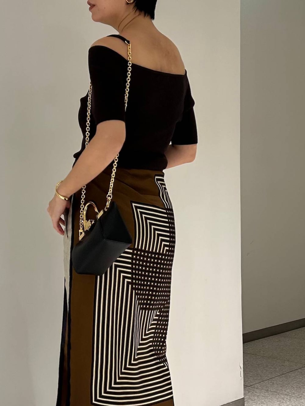 ホワイト系のスラックス、ブラウン系のTシャツ/カットソー、ブラウン系のバンダナ/スカーフを着用したレディースの春コーディネートの9枚目の写真