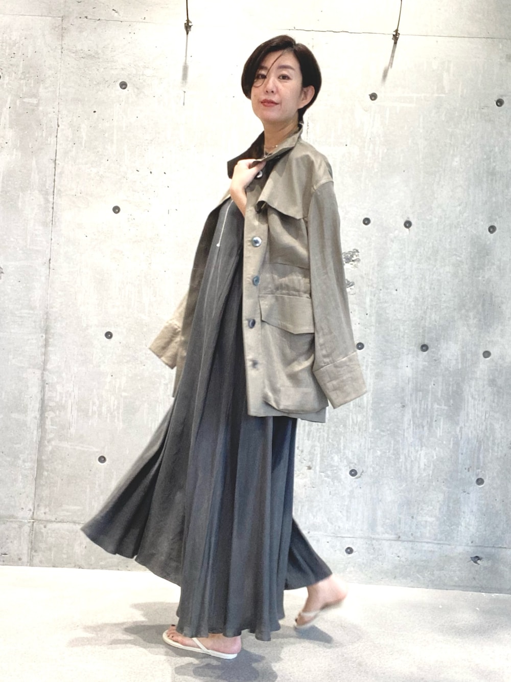 ベージュ系のジャケット/アウター、グレー系のワンピース/ドレス、ベージュ系のサンダルを着用したレディースの夏コーディネートの2枚目の写真