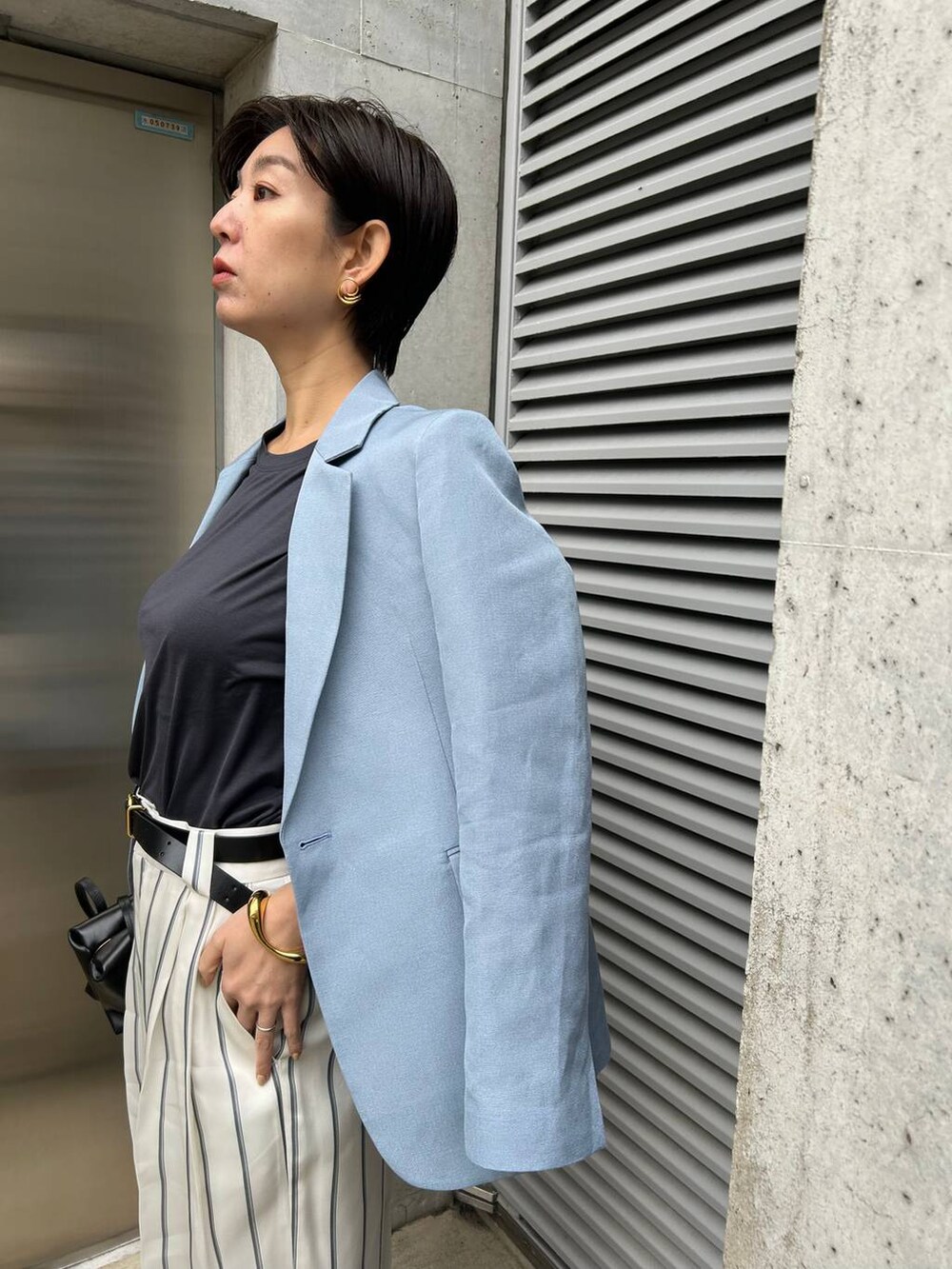 ホワイト系のスラックス、ブルー系のTシャツ/カットソー、ブルー系のテーラードジャケットを着用したレディースの春コーディネートの6枚目の写真