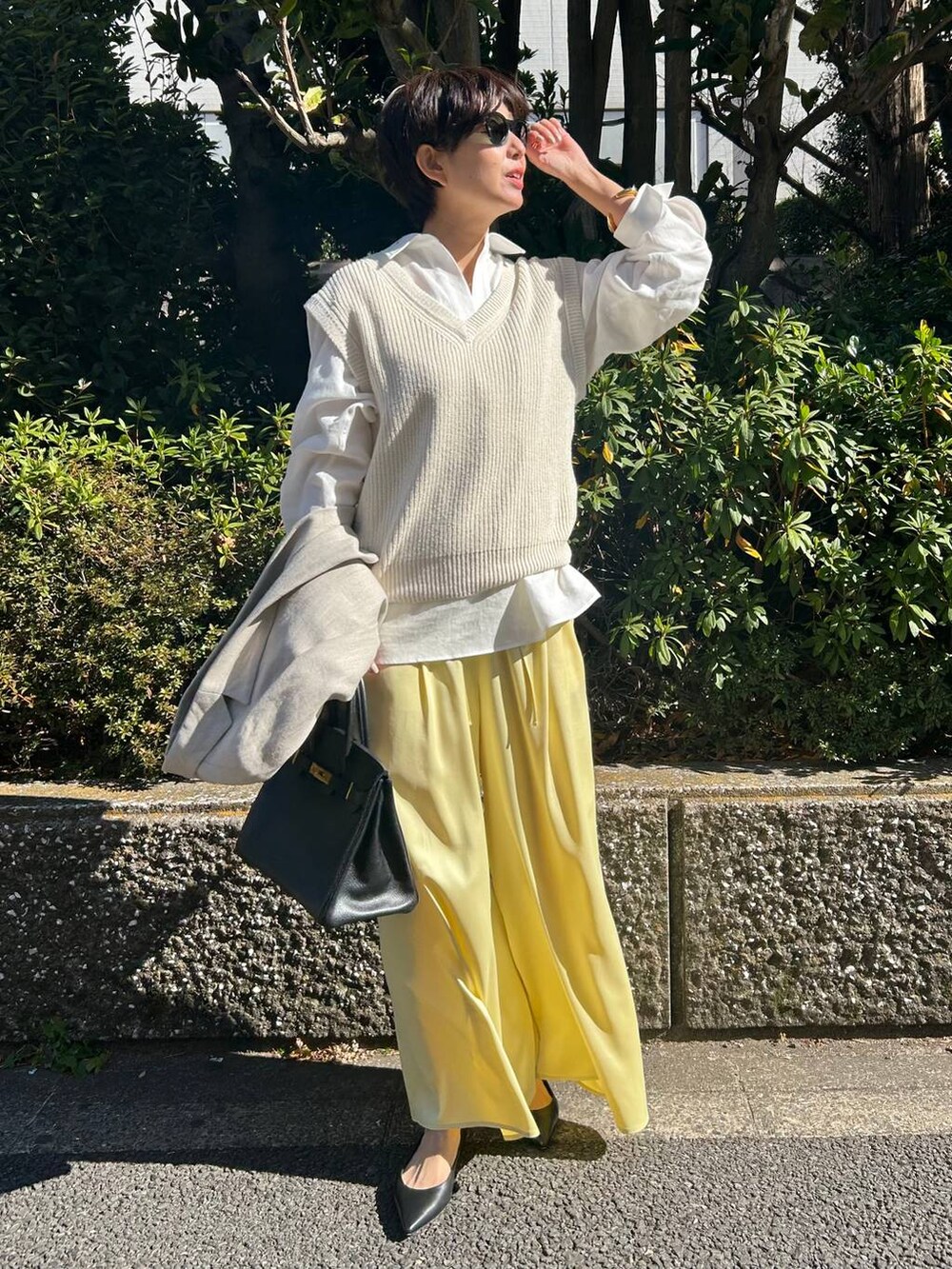 イエロー系のその他パンツ、ホワイト系のベスト、ベージュ系のテーラードジャケットを着用したレディースの冬コーディネートの2枚目の写真