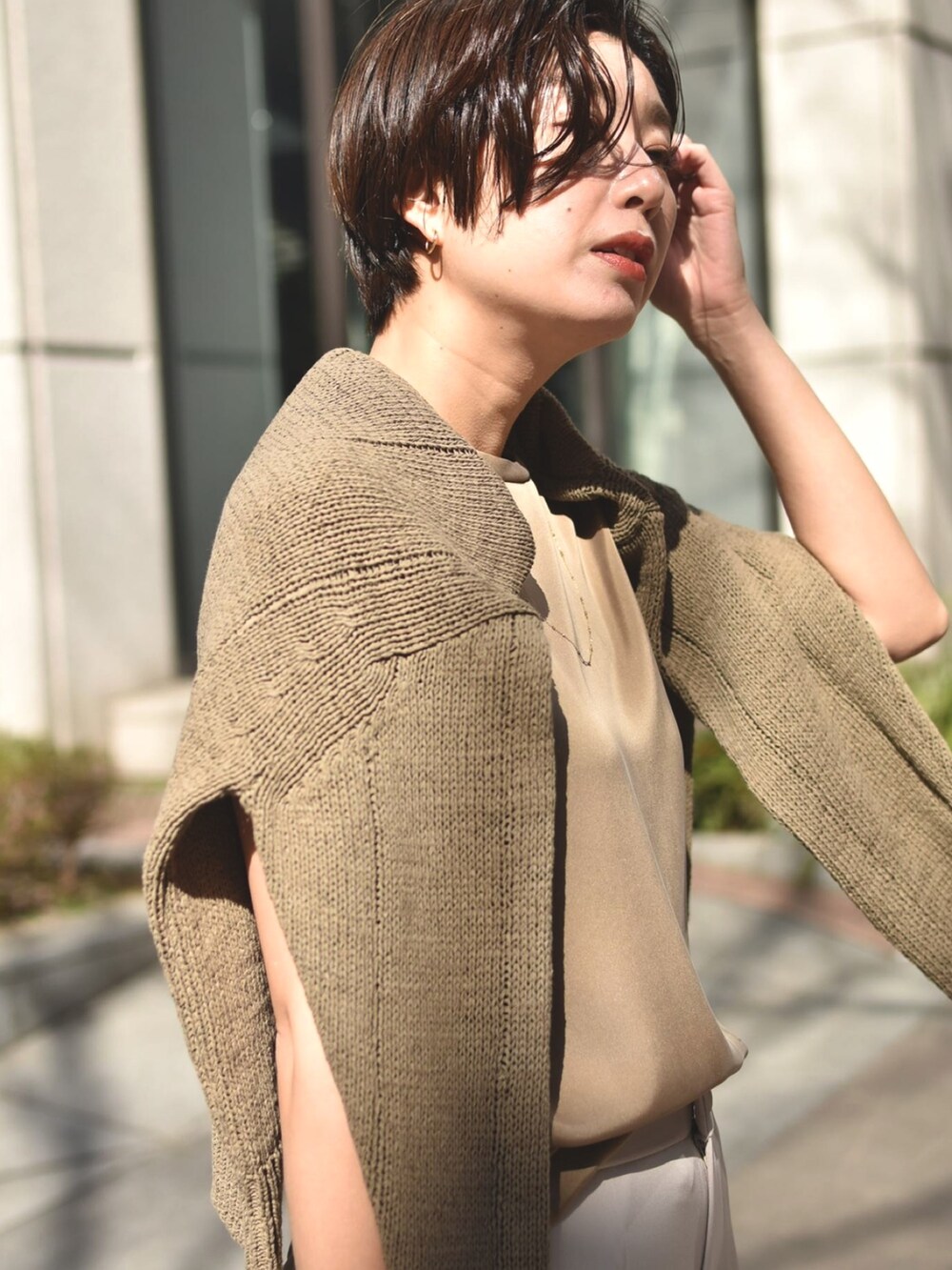 ブラウン系のニット/セーター、ブラウン系のTシャツ/カットソー、ベージュ系のパンツを着用したレディースの春コーディネートの4枚目の写真