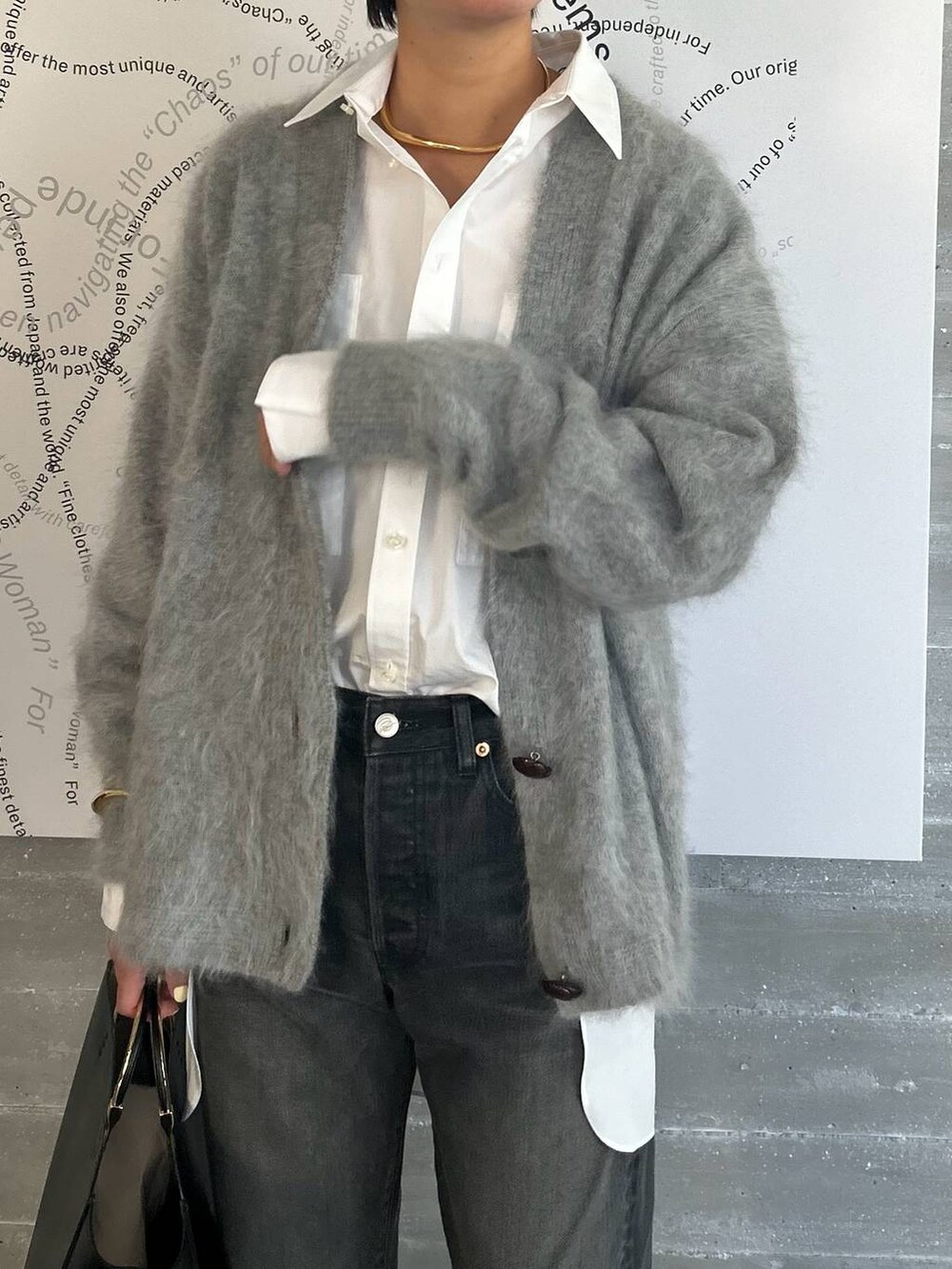 ブラック系のデニムパンツ、ホワイト系のシャツ/ブラウス、グレー系のカーディガン/ボレロを着用したレディースの夏コーディネートの4枚目の写真
