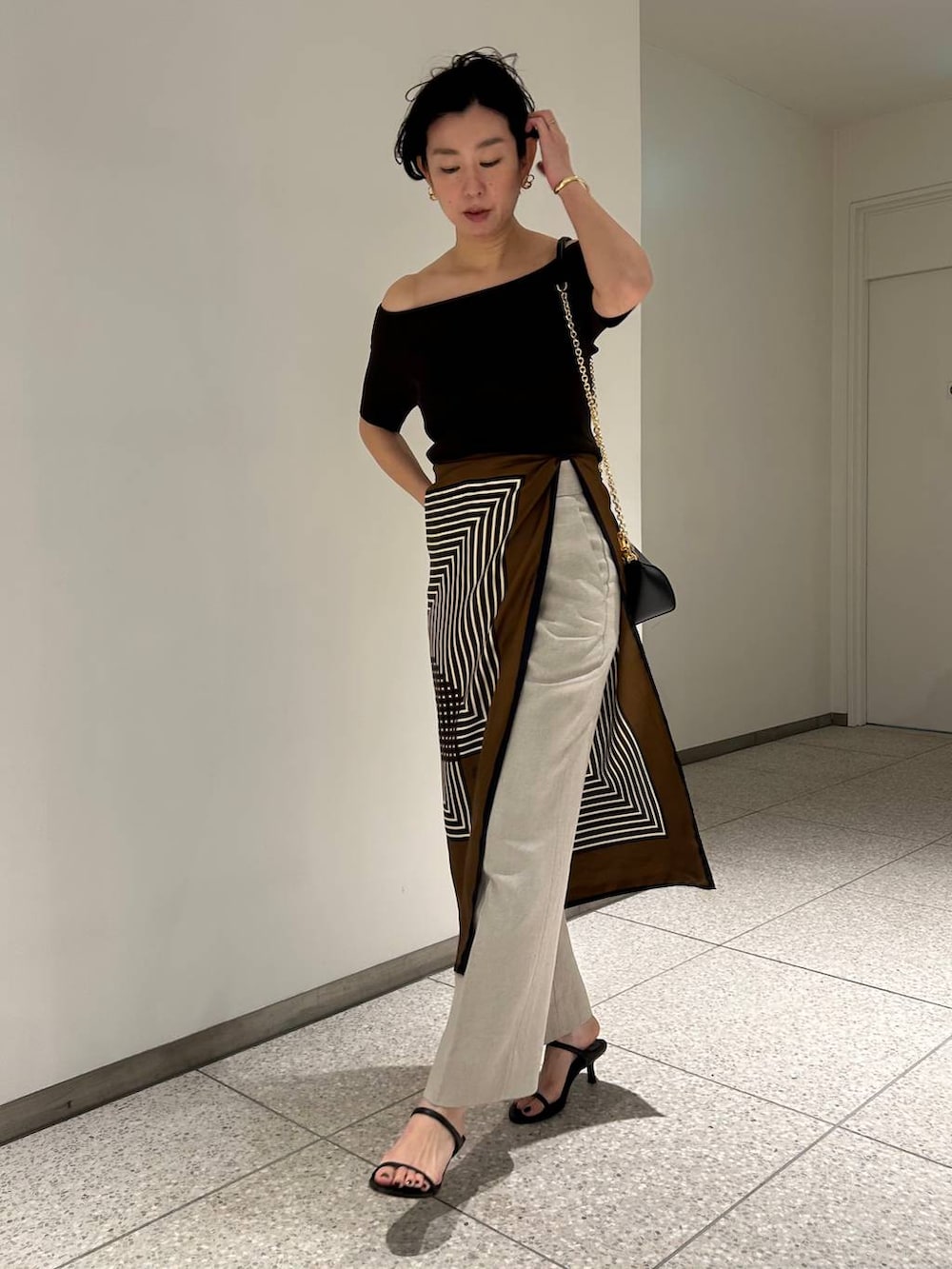 ホワイト系のスラックス、ブラウン系のTシャツ/カットソー、ブラウン系のバンダナ/スカーフを着用したレディースの春コーディネートの7枚目の写真