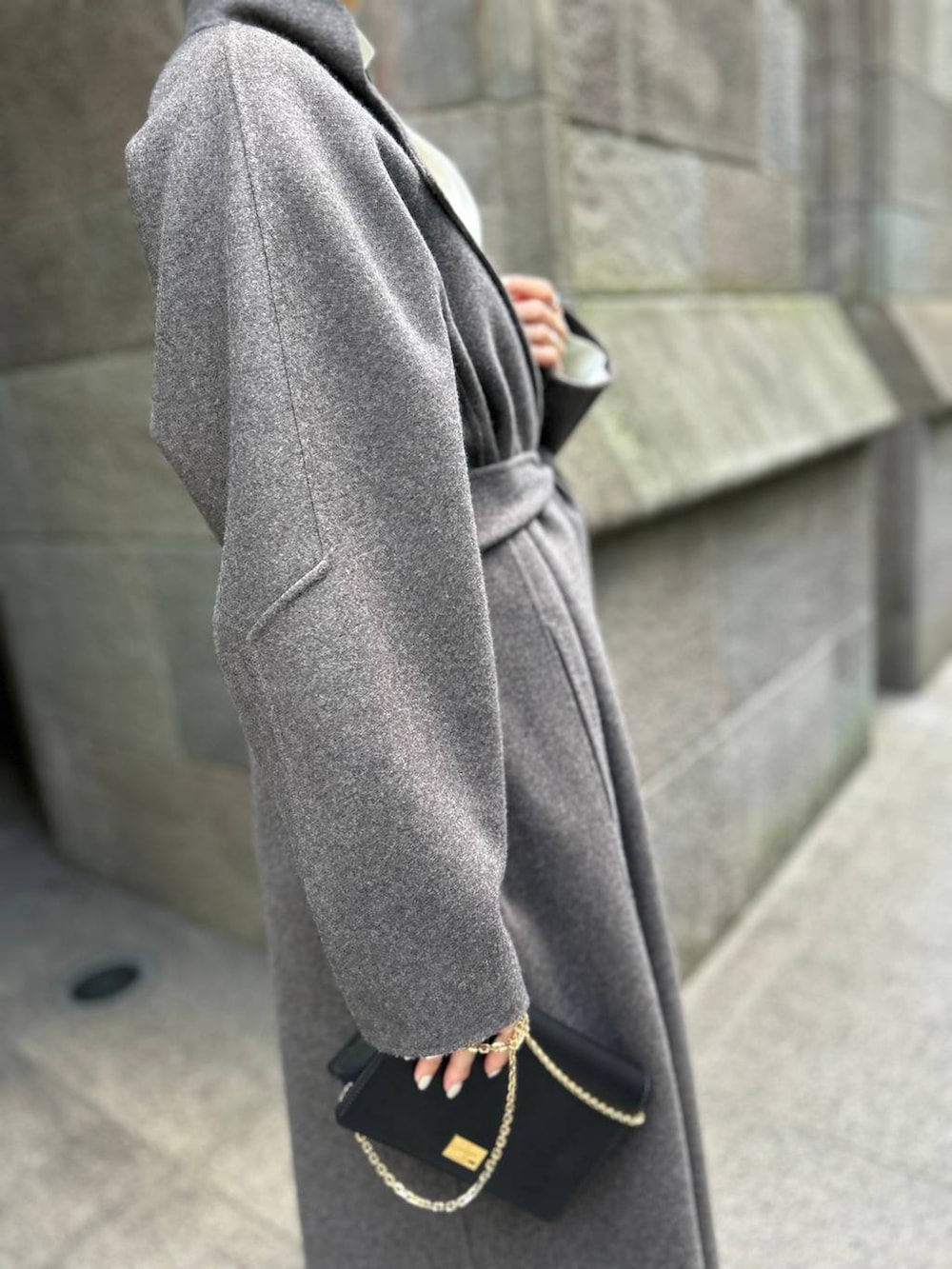 ブラウン系のノーカラーコート、ホワイト系のスラックス、ホワイト系のシャツ/ブラウスを着用したレディースの秋コーディネートの9枚目の写真