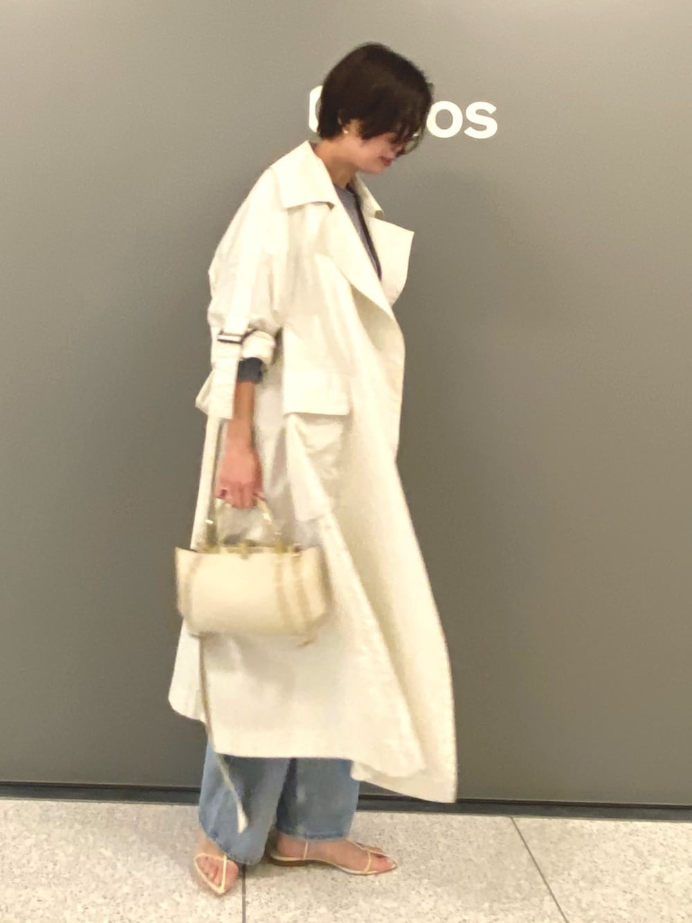 グレー系のジャケット/アウター、ブルー系のニット/セーター、ベージュ系のバッグを着用したレディースの冬コーディネートの3枚目の写真