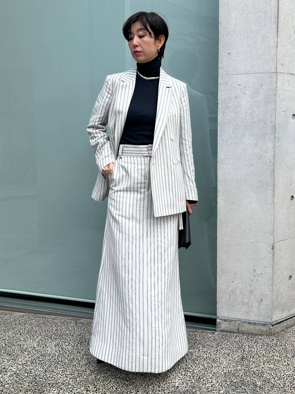 ブルー系のニット/セーター、ホワイト系のテーラードジャケット、ホワイト系のスカートを着用したレディースの冬コーディネートの3枚目の写真