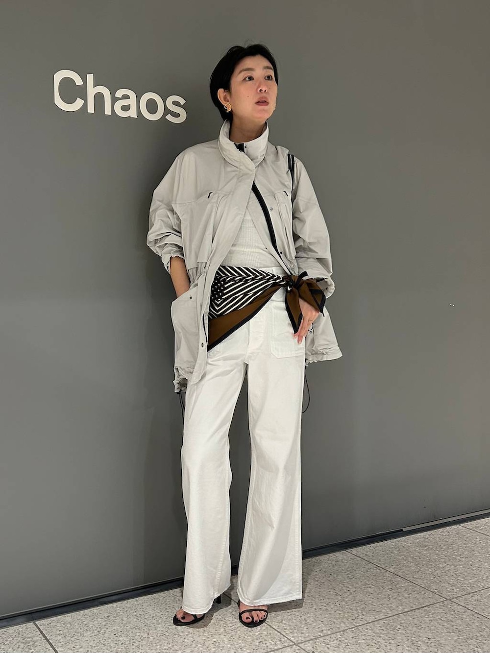 ホワイト系のデニムパンツ、ホワイト系のタンクトップ、グレー系のブルゾンを着用したレディースの春コーディネートの2枚目の写真