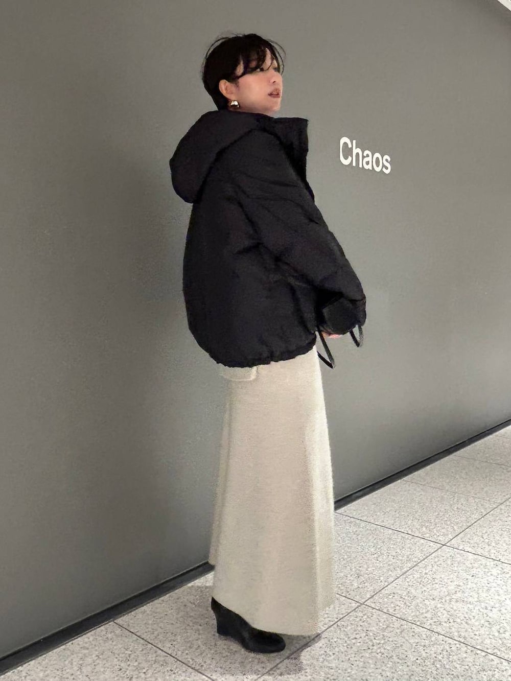 ベージュ系のニット/セーター、ベージュ系のスカート、グレー系のダウンジャケット/コートを着用したレディースの秋コーディネートの4枚目の写真