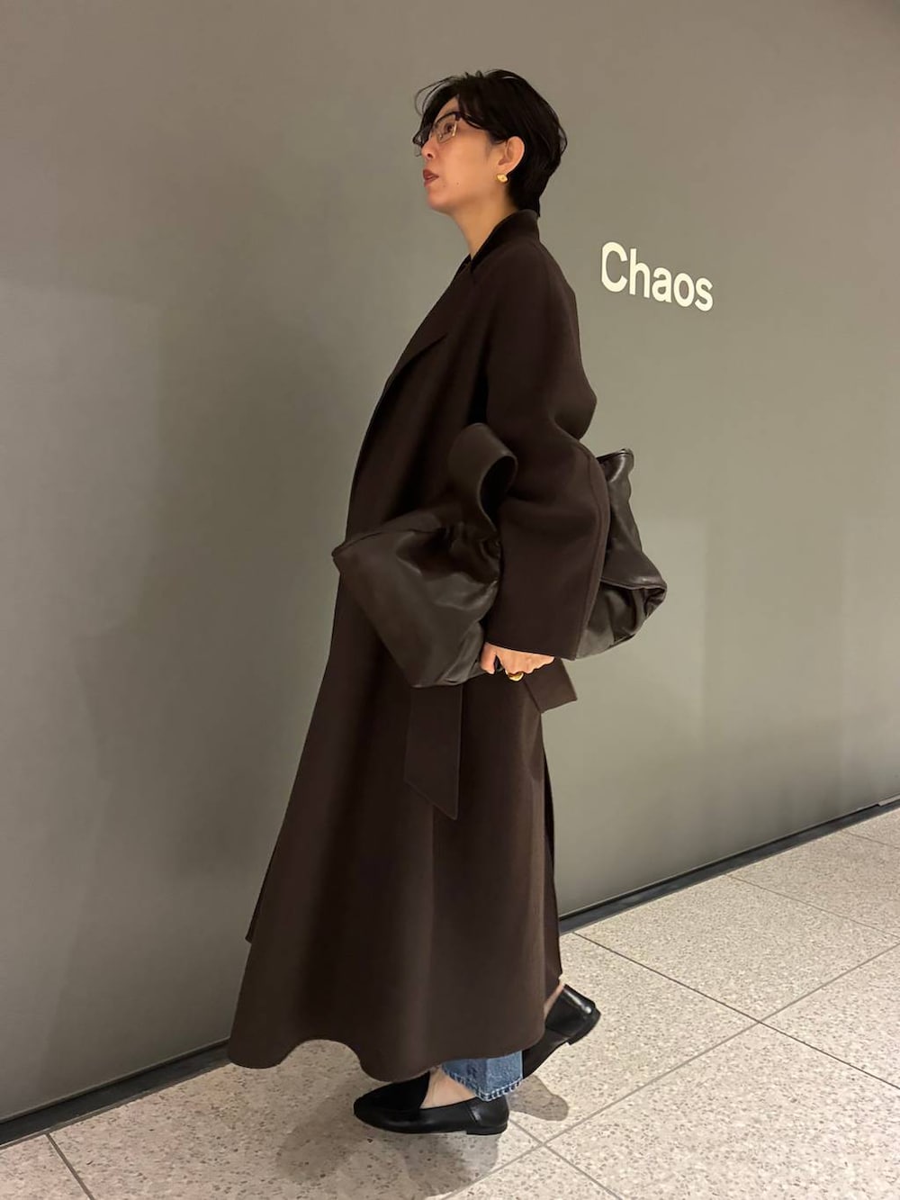 ブルー系のデニムパンツ、ブラウン系のニット/セーター、ブラウン系のノーカラーコートを着用したレディースの秋コーディネートの2枚目の写真