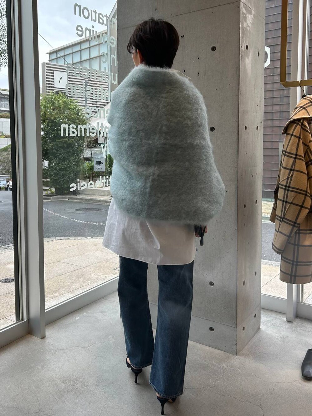 ブルー系のデニムパンツ、ホワイト系のシャツ/ブラウス、ブルー系のマフラーを着用したレディースの秋コーディネートの4枚目の写真